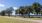 a path with trees and grass by a body of water