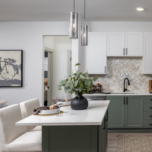 Townhomes in Clermont, FL - Broadstone Overlands - Fully-Equipped Kitchen with Stainless Steel Appliances, Entertainment-Sized Kitchen Island, Designer Lighting, Quartz Countertops, Herringbone Tile Backsplash, Two-Tone Custom Kitchen Cabinets, and Single