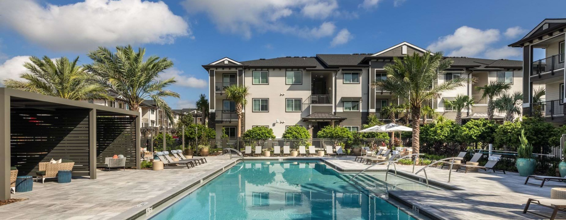 a courtyard with a swimming pool and lounge chairs