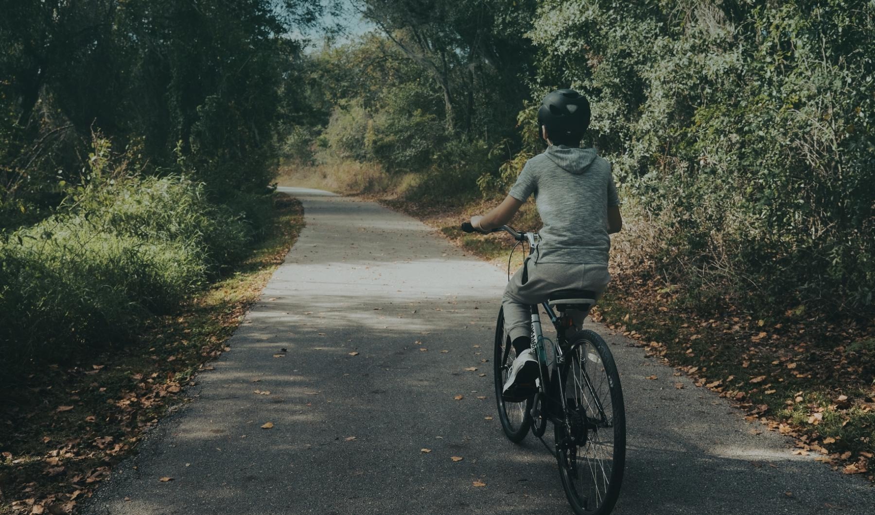 a man riding a bike on a path in the woods